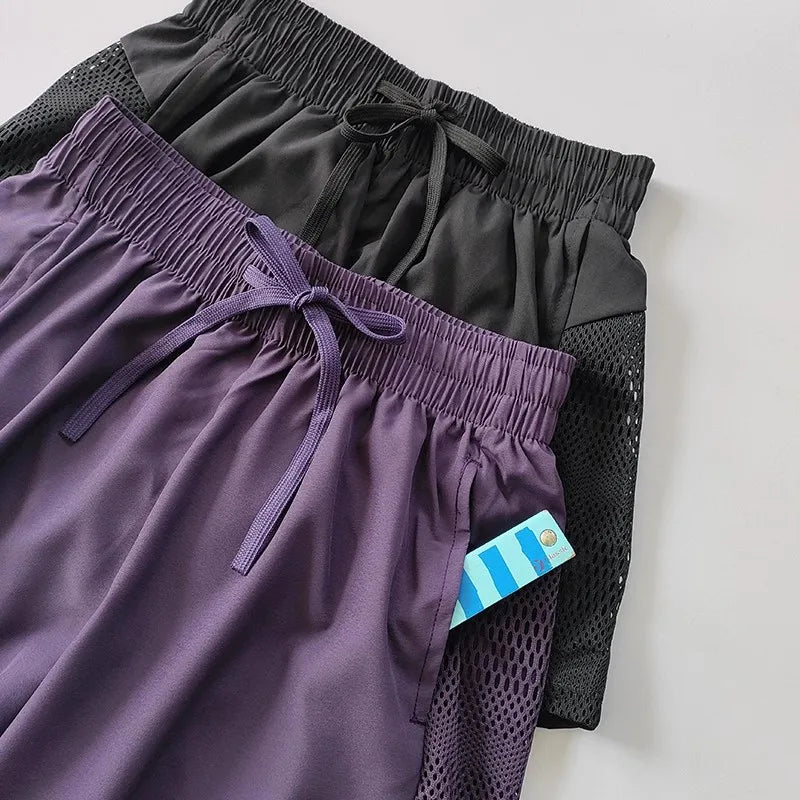 Breathable gym shorts for women in purple and black with elastic waistband and adjustable drawstring