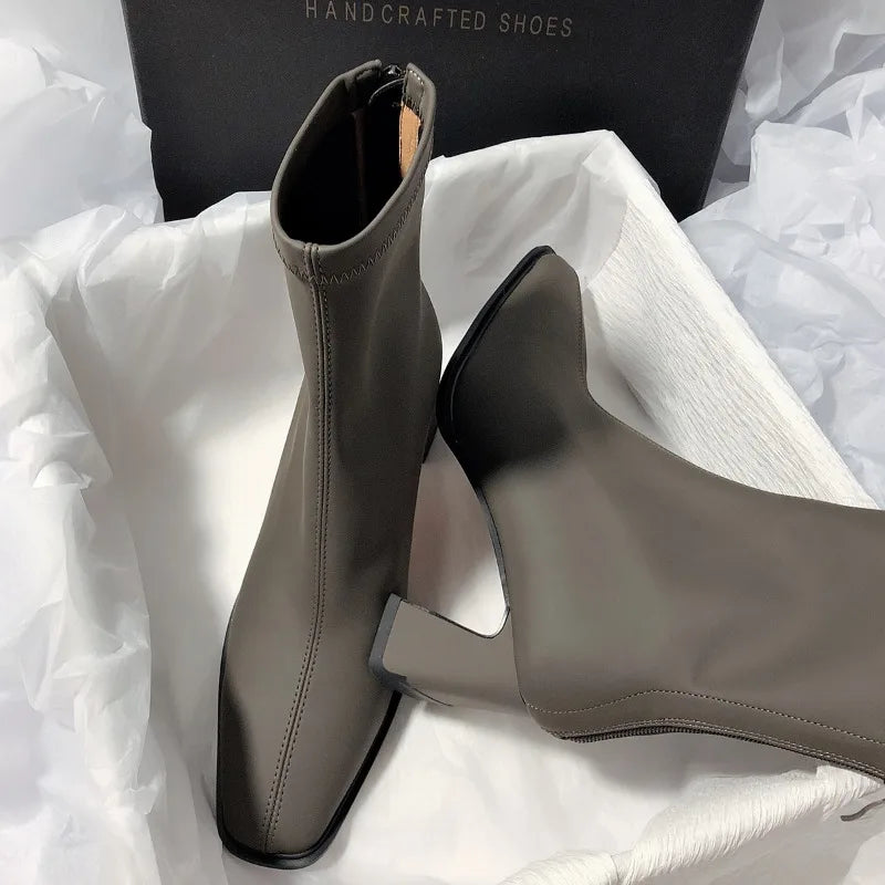 Gray fashion boots with back zipper featuring square toes and block heels inside a white box