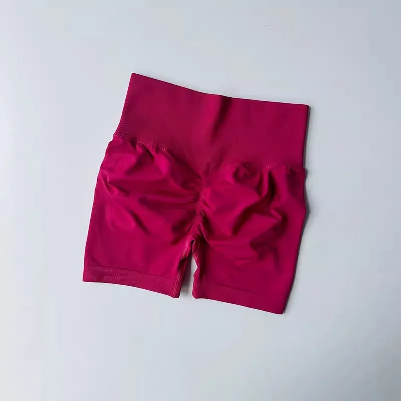 High-waist yoga shorts women in vibrant pink color with a flattering fit and ruched detail