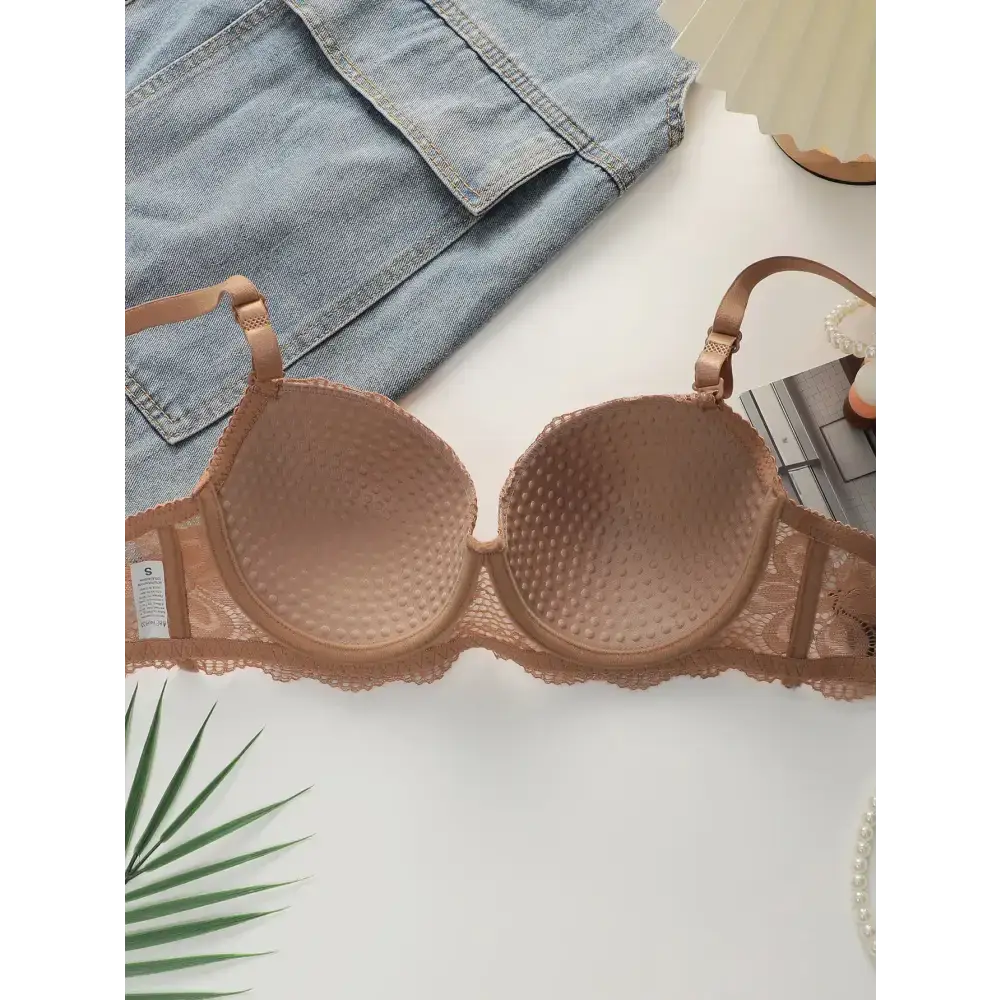 Beige textured bra from 2-piece underwear set by The Lady's Haven Boutique displayed with denim and decorative items